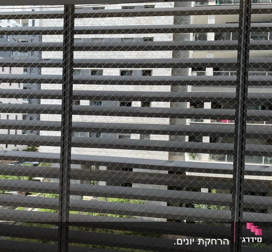 רשת מתכת על חלון למניעת כניסת יונים